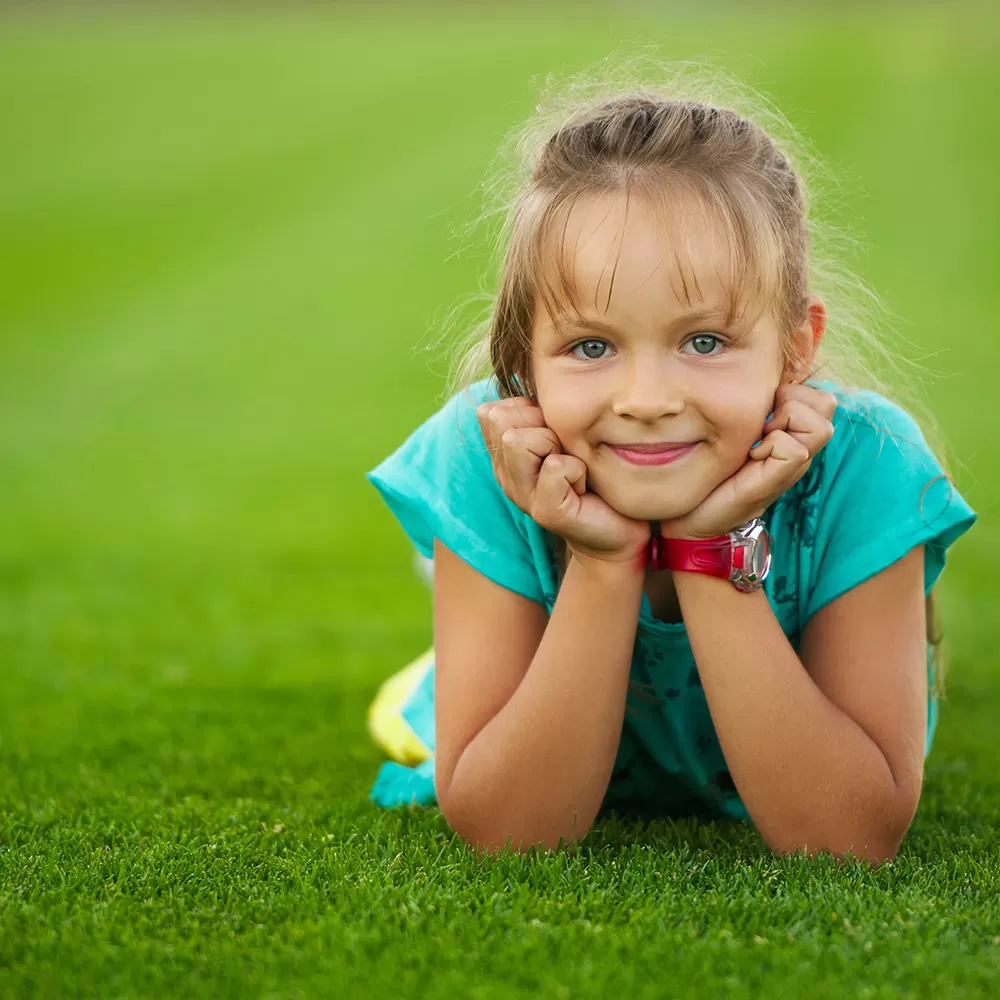 little girl lying on grass turf