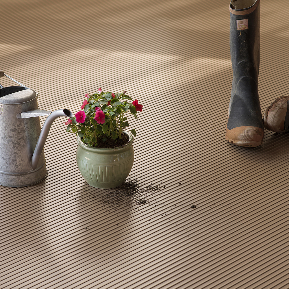 Flowers, boots and water can on G-Floor Ribbed Tread Garage Floor Roll 55 mil x 8.6x22 Ft. in sandstone