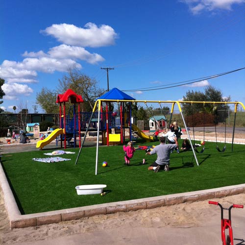 playground with artificial turf surrounded by sand