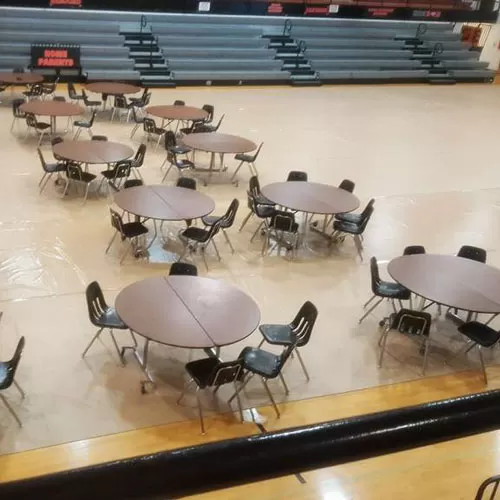 rolls of vinyl covering a gym floor for a dance or event