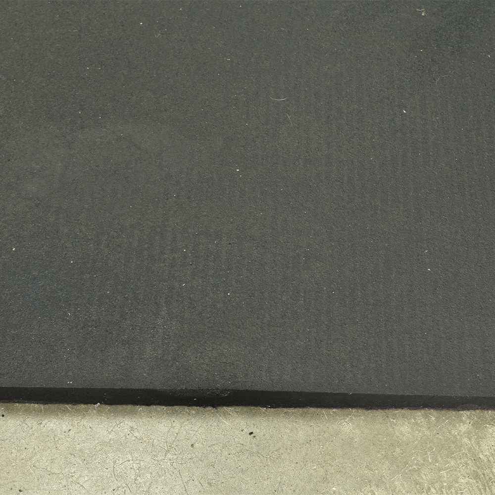 close up of edge of smooth top straight edge horse stall mat over concrete