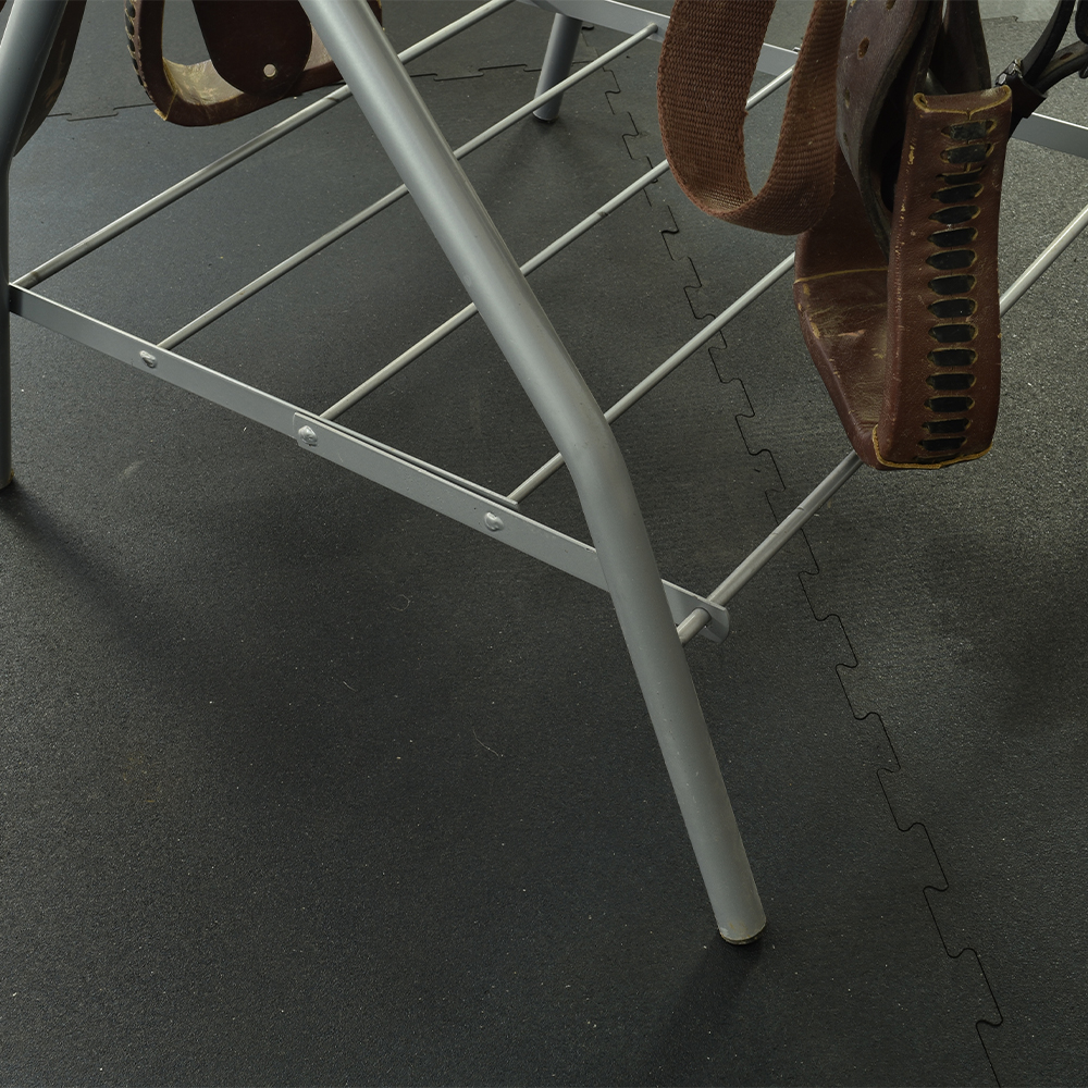 rubber interlocking horse stall mats in tack room with saddle rack