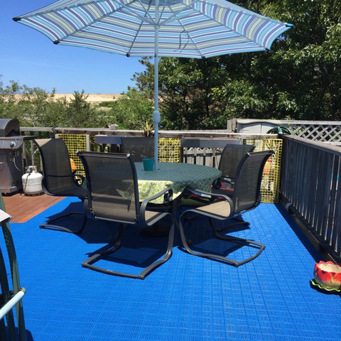 blue outdoor patio deck tiles over old wood deck with table and umbrella