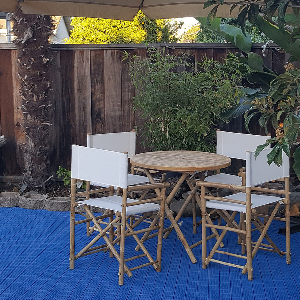 blue plastic outdoor tiles on concrete patio with table and chairs