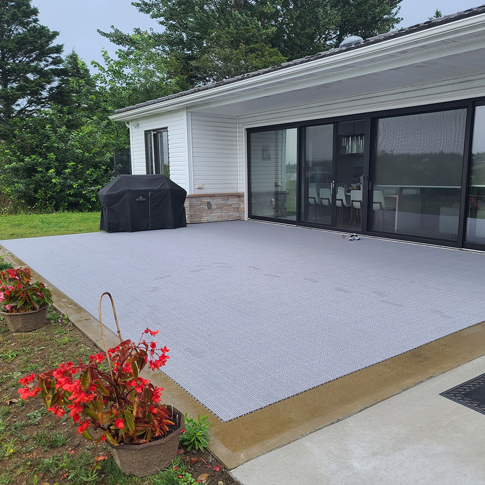 installation of gray outdoor flooring tiles over top of concrete patio 
