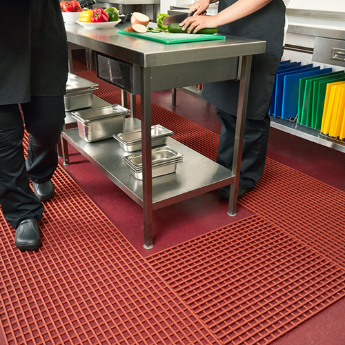 orange open grid mats on commercial kitchen floor