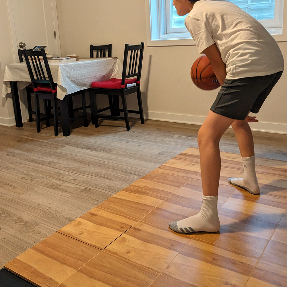 indoor basketball court tiles in living room with boy dribbling ball