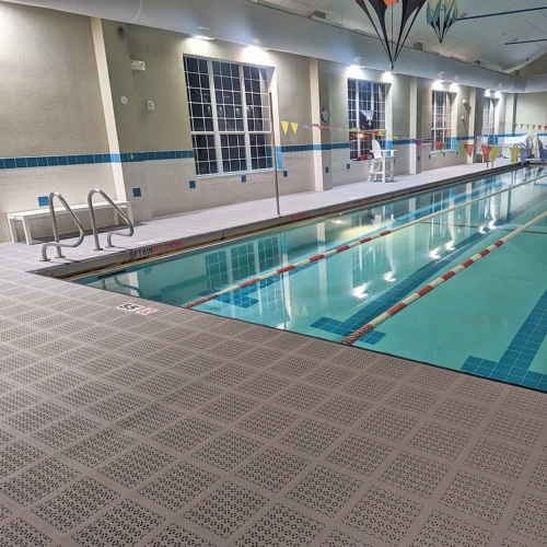 indoor pool with grey perforated tiles surrounding pool