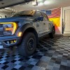 garage with truck showing black and gray raised interlocking tiles for flooring