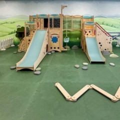 indoor playground for kids inside a cafe restaurant with green floor mats