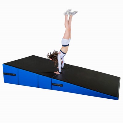 cheerleader practicing on blue and black folding incline wedge mat